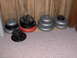 1996 Chevrolet Cavalier - Various weight plates are stacked on a carpeted floor and a wooden shelf against a wood-paneled wall.