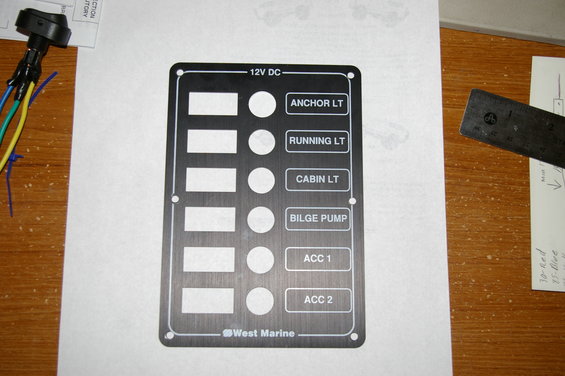 Black West Marine 12V DC switch panel with labels for ANCHOR LT, RUNNING LT, CABIN LT, BILGE PUMP, ACC 1, and ACC 2
