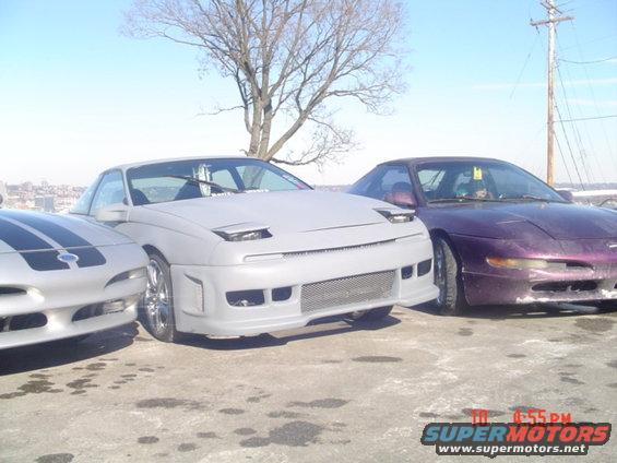 Three coupes parked together, light gray, purple, and silver with black stripes