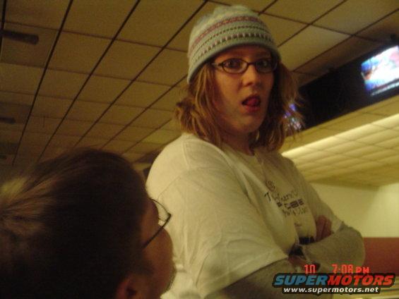 Person with tongue sticking out, wearing a beanie and glasses