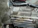 1985 Ford Bronco II - Close-up view of a damaged transmission casing showing an oil leak.