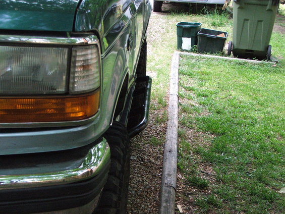 Green SUV front corner with chrome bumper and amber turn signal