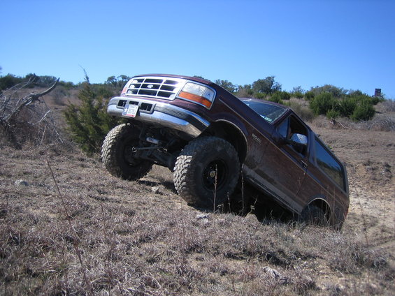 Brown 1996 Ford Bronco climbing a hill, 3q-front view