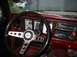 1979 Ford Bronco - The dashboard of a vintage truck features a wood-grain trim and an aftermarket steering wheel.