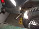 1995 Ford Mustang - Close-up view of a vehicle's rear tire and exhaust system, supported by a yellow jack.
