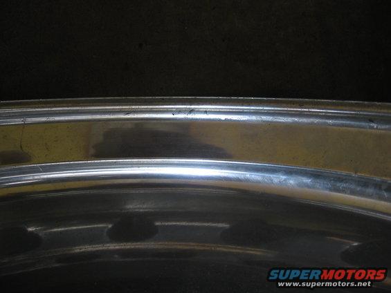 Close-up of a chrome wheel rim with some scratches and reflections