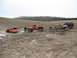 1984 Ford Bronco - Multiple off-road vehicles navigate a muddy terrain, with one orange SUV partially submerged.