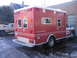 1984 Ford F-350 - Rear view of a red ambulance truck parked next to a pickup truck.