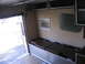 1984 Ford F-350 - Interior view of a trailer showing bench seating, overhead storage, and a framed picture on the wall.