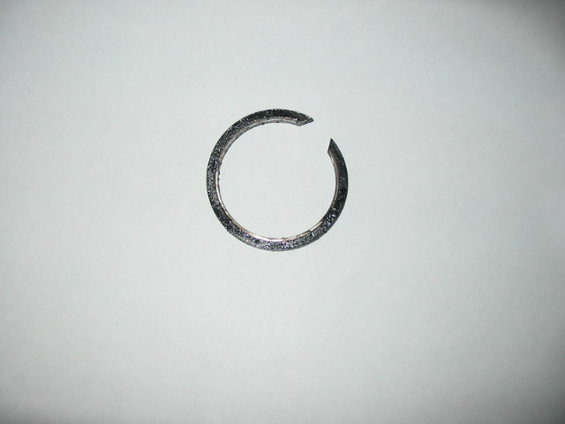 Broken metal ring with textured surface, isolated on white background