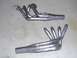 1990 Ford Mustang - Two sets of exhaust headers are shown on a concrete surface. One set is positioned above the other.