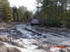 1995 Dodge 1500 - A red pickup truck navigates a challenging, icy path surrounded by dense woods.