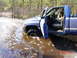 1995 Dodge 1500 - A blue 1995 Dodge 1500 pickup truck is stuck in shallow, icy water with the driver's side door open.