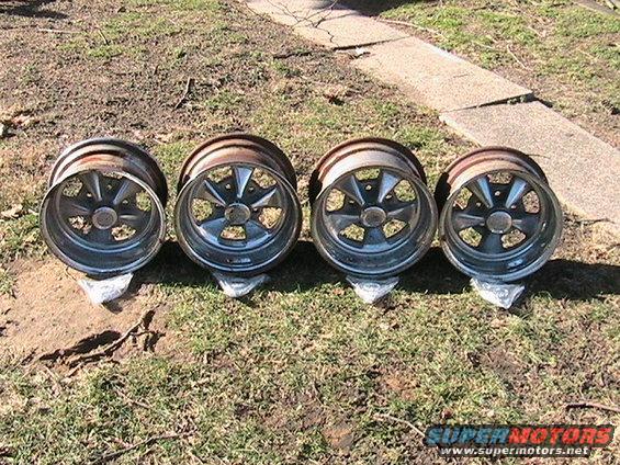 Four chrome five-spoke wheels on the ground