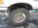 1994 Ford Bronco - The front wheel and lower fender of a 1994 Ford Bronco are shown in this close-up shot.