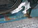 1994 Ford Bronco - Close-up of a vehicle's rusted door sill with snow and melting ice.