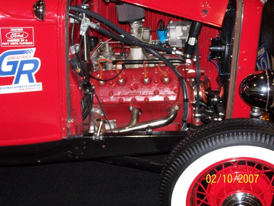 Red engine bay with Ford logo and Great Race decals on the side panel. Date 02/10/2007 visible on wheel