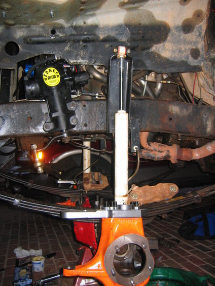Close-up of steering gear and shock absorber assembly with leaf springs visible