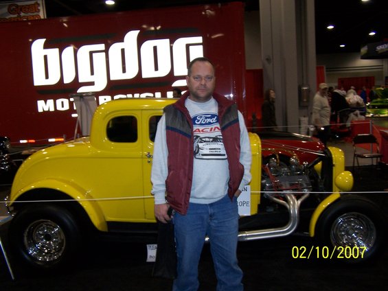 Yellow hot rod coupe with exposed engine and chrome wheels