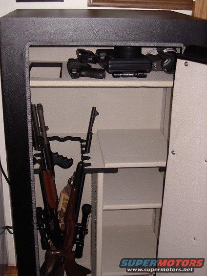 Gun safe interior with rifles and handguns stored on shelves and racks