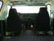 1979 Ford Bronco - The interior of this 1979 Ford Bronco shows black seat covers, a green dashboard, and a fire extinguisher mounted between the seats.
