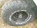 1979 Ford Bronco - Close-up of a Goodyear Wrangler tire and black rim, showing the hub assembly.