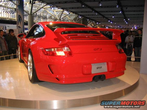 Red Porsche 911 GT3 with large rear spoiler and dual exhaust pipes