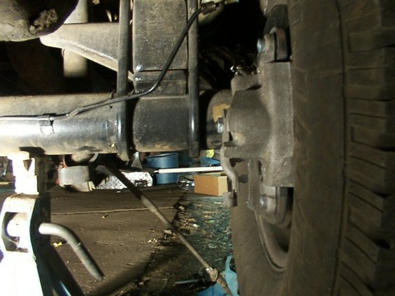 Rear axle and brake assembly with a tire visible