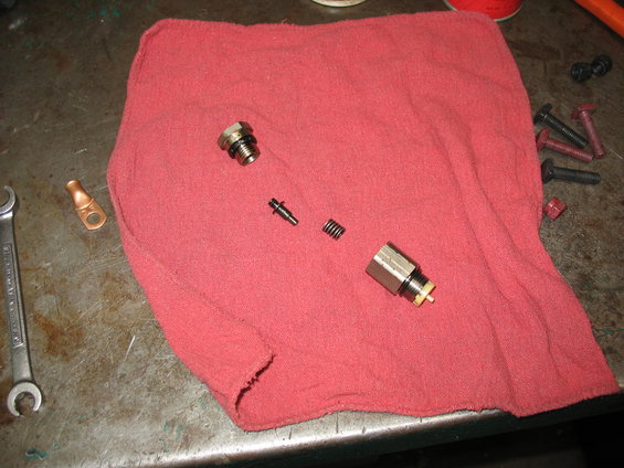 Brake caliper piston and disassembled parts on red cloth