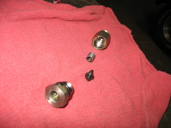 Disassembled brake caliper parts on a red cloth
