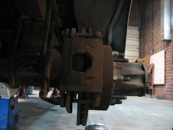 close-up of rusty truck brake caliper and rotor assembly