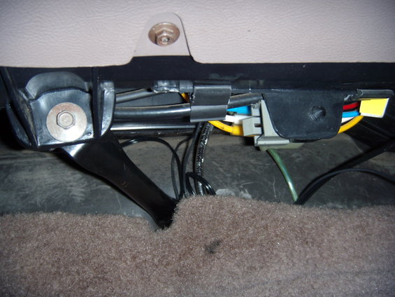 Under-seat wiring harness with black and yellow wires, gray connector, and green cable
