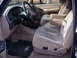 1992 Ford Bronco - The interior of a Ford truck features cloth seats, a tan dashboard, and a black steering wheel with a Ford emblem.