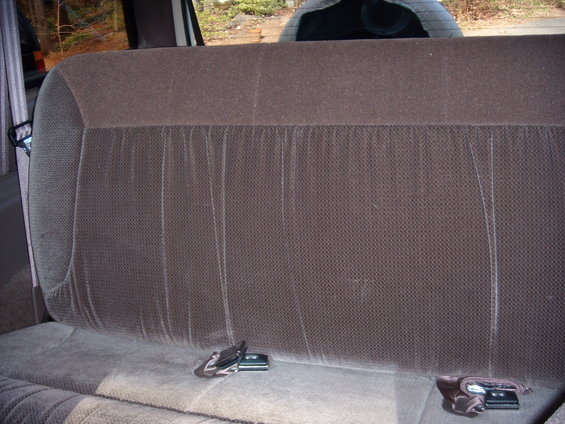 Rear seat interior with brown fabric upholstery and seatbelts