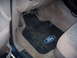 1992 Ford Bronco - The interior of a vehicle shows a black Ford-branded floor mat and the brake and gas pedals.