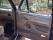 1992 Ford Bronco - Interior view of a 1992 Ford Bronco, showing the door panel, dashboard, and floor mat.