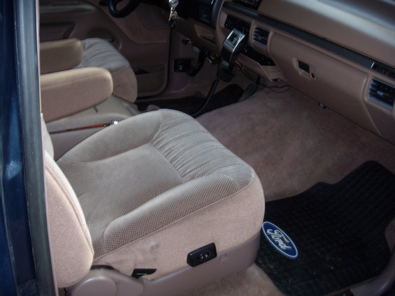 1992 Ford Bronco interior showing tan seats, dashboard, and floor mats with Ford logo