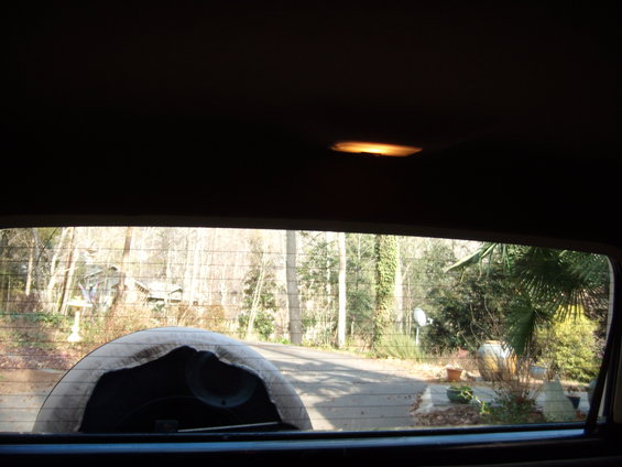 Spare tire cover obscuring view through rear window of a vehicle