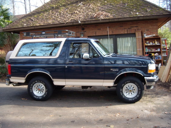 1992 Ford Bronco side view, dark blue and tan with roof rack