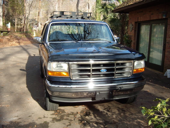 Black 1992 Ford Bronco with a roof rack, parked in a driveway