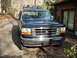 1992 Ford Bronco - Front view of a black 1992 Ford Bronco with a roof rack, parked outdoors.