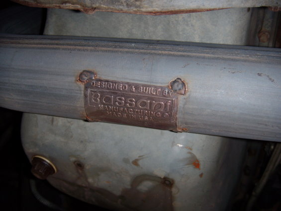 Exhaust pipe with a metal plate reading 'DESIGNED & BUILT BY Bassani MANUFACTURING CO. MADE IN USA.'
