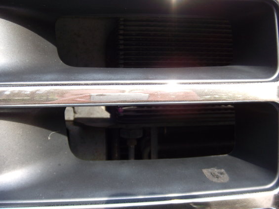 Close-up of a dark grille with horizontal bars and a chrome accent strip