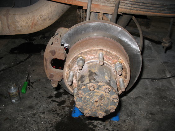 Close-up of a vehicle's rear axle brake assembly with a rotor and caliper