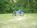 2004 Yamaha YFZ450 - A blue Yamaha YFZ450 ATV is parked on a grassy field with trees behind it.