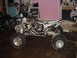 2004 Yamaha YFZ450 - A custom build appears to be underway, with an ATV frame housing a motorcycle engine, beside a parked motorcycle.