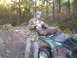 2005 Yamaha GRIZZLY 660 - Hunter poses with a deer on the seat of a green 2005 Yamaha GRIZZLY 660 ATV in a wooded area.