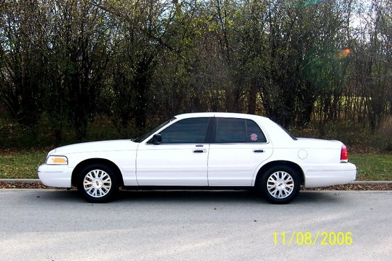 White 2003 Ford Crown Victoria sedan parked on asphalt, side view