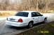 2003 Ford Crown Victoria - Rear view of a white 2003 Ford Crown Victoria parked curbside on a sunny day.