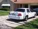 2003 Ford Crown Victoria - Rear view of a white 2003 Ford Crown Victoria sedan parked on a concrete driveway.